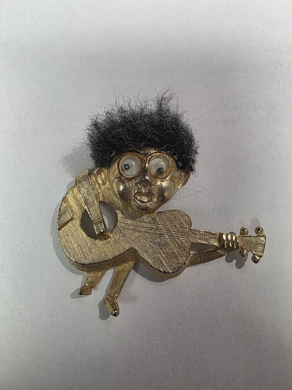 This is a vintage 1964 PAN Gold Tone Googly Eyed Guitarist Brooch from the Beatl